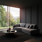 Modern living room with a gray sectional sofa, coffee table, and large window view of trees and mountains.