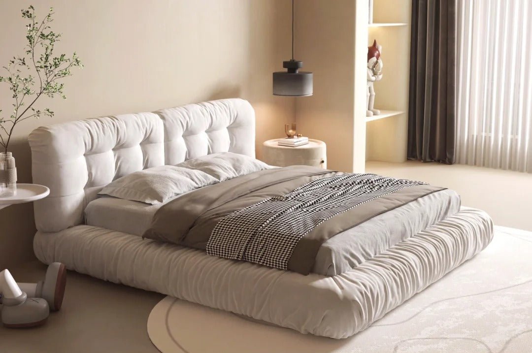 Italian-style cloud bed in ivory suede fabric, displayed in a beige modern bedroom with a carpet under it.