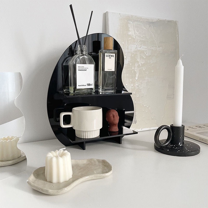 Acrylic Desktop Organizer in black, holding perfumes and a mug on a modern white vanity setup