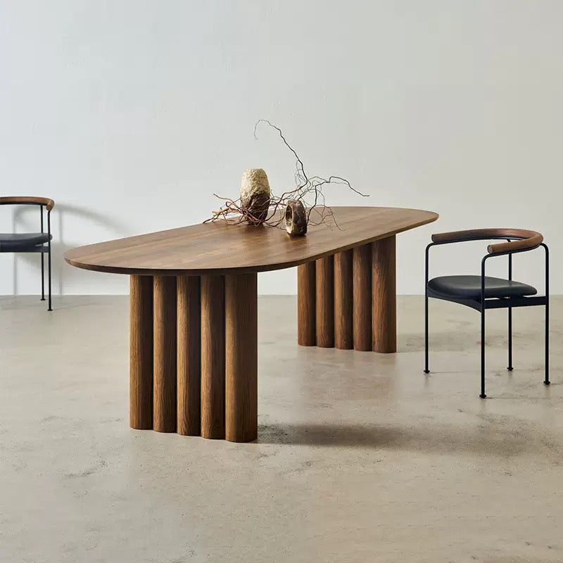Adrian solid wood dining table with fluted legs and walnut finish in minimalist neutral room