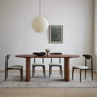 Adrian solid wood dining table with walnut finish styled with four chairs in modern living room