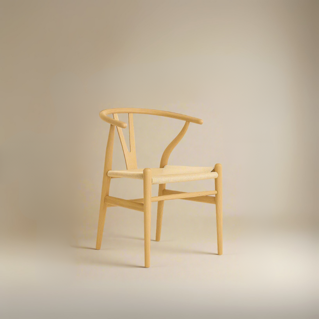 Alden Wishbone Dining Chair with a natural wood frame and woven seat, shown in a soft neutral studio setting.
