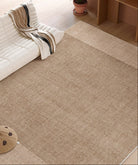 Close-up view of the Alpine Luxe Rug in warm beige, showing its soft texture beside a white sofa and wooden flooring.