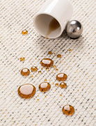 Close-up of the Alpine Luxe Rug showing water-repellent performance with spilled droplets beading on the surface