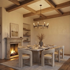 Dining room with wooden beams, fireplace, and modern furniture.