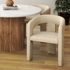 Archway Dining Chair in a modern dining space, featuring a curved upholstered design paired with a round marble and wood table