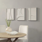 Arcus Relief wall art set displayed in a styled dining space with sculpted white panels mounted on a soft grey wall