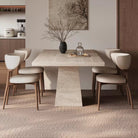 Front view of Ardella sintered stone dining table with trapezoid base and beige chairs in warm modern dining setting