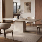 Side view of Ardella sintered stone dining table in warm modern dining space with beige chairs and soft natural lighting