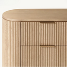 Macro detail of the Arden dresser showing the minimalist brass finger pull handles and precision-milled vertical wood fluting.