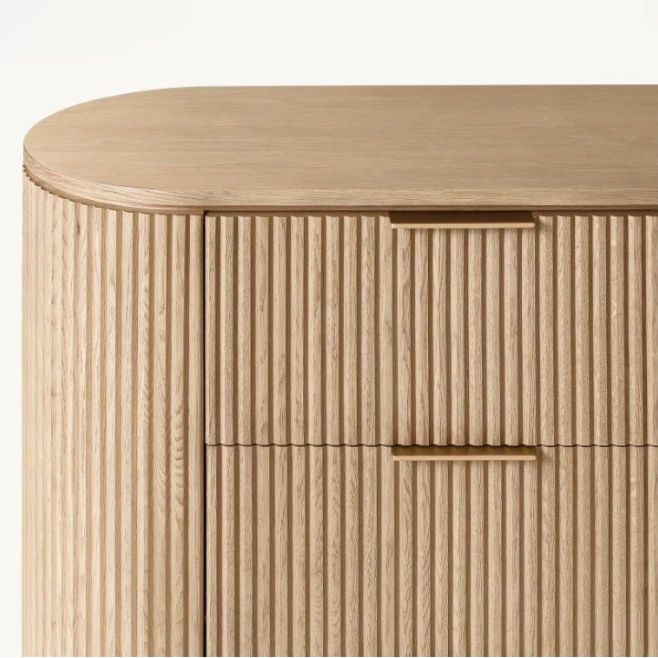 Macro detail of the Arden dresser showing the minimalist brass finger pull handles and precision-milled vertical wood fluting.