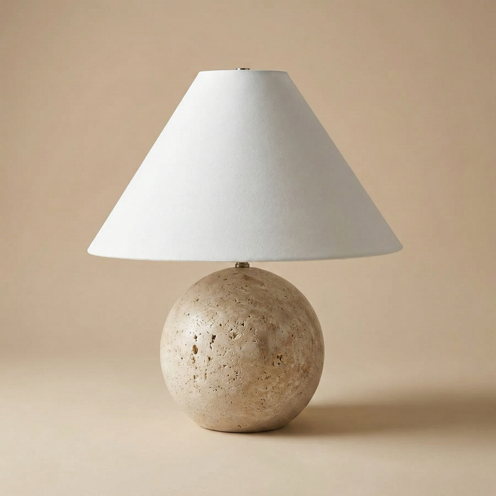 Table lamp with a stone-like base and white shade on a beige background