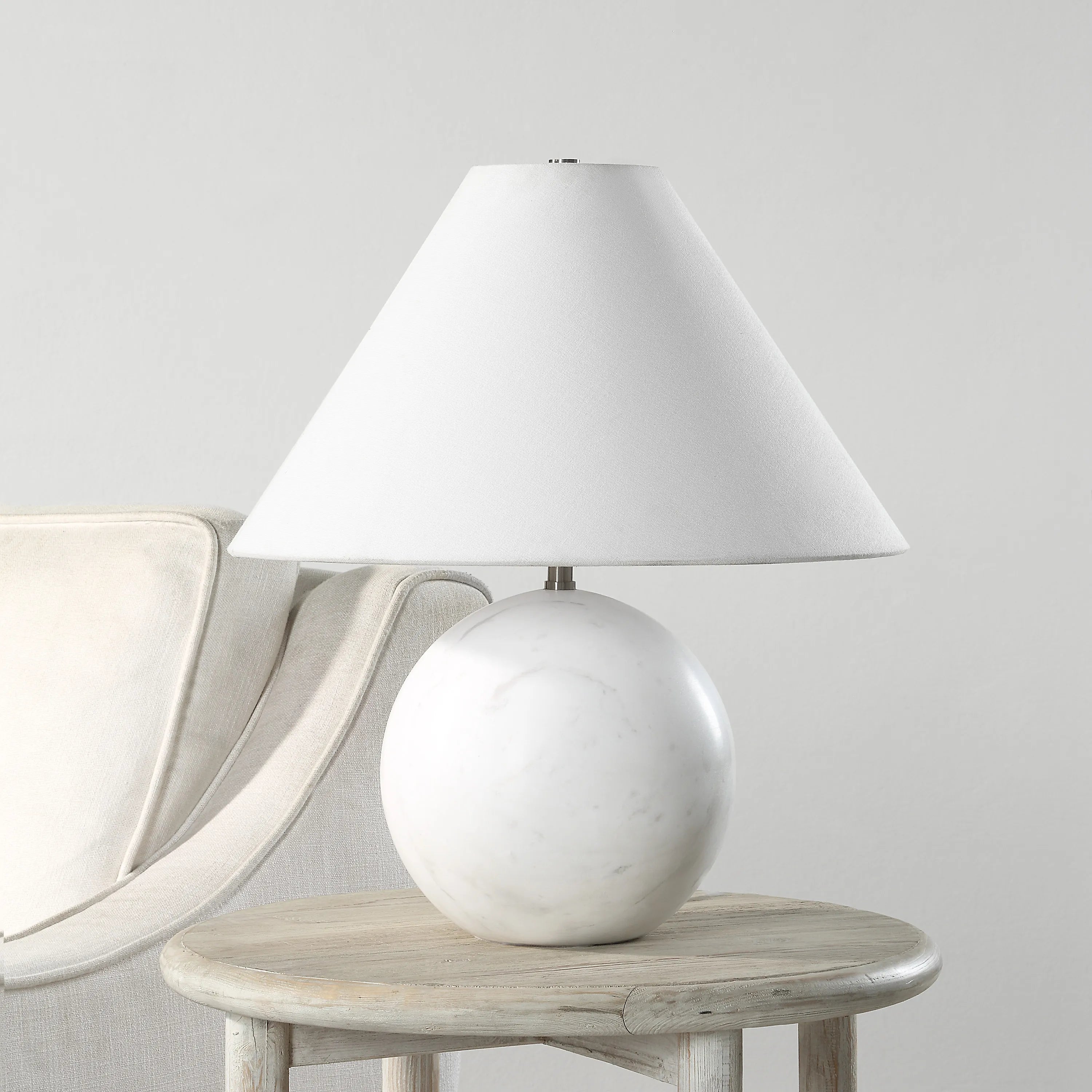 Arlo White Marble Sphere Table Lamp on round wooden side table beside cream armchair in minimal neutral living space