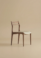 Wooden chair with a white faux leather cushion on a beige background