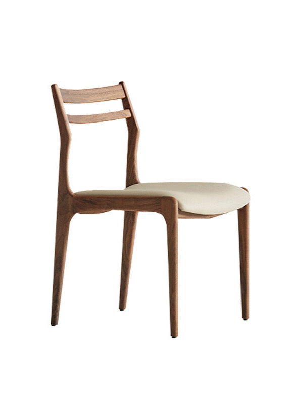 Aspen Classic Dining Chair with walnut wood frame and light upholstered seat in a minimalist studio setting