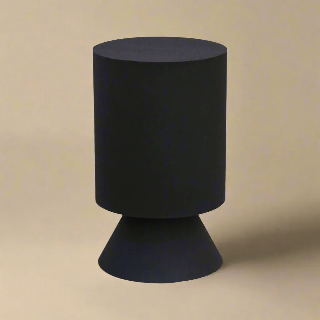 Atlas side table featuring a modern geometric design with a cylindrical top and conical pedestal base in matte black.