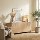 Aurelian oak buffet styled in a warm neutral room with a mushroom lamp and dried botanicals next to a beige armchair.