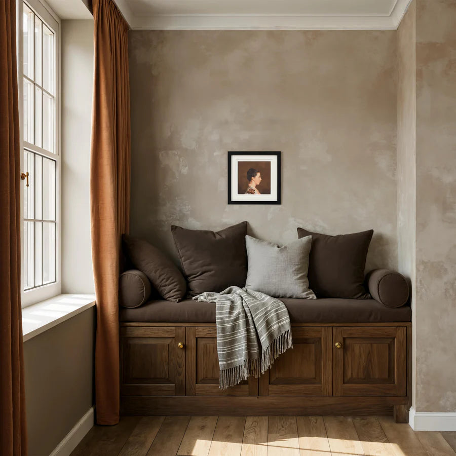 The Beatrice profile wall art styled above a cozy wooden built-in bench with brown pillows in a warm neutral room.