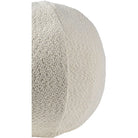 Side view of the ivory bouclé sphere pillow highlighting the intersecting seam detail that gives it a perfect round shape.