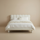Front view of the Bubbly Bliss bed featuring a button-tufted headboard and rounded legs in cream boucle fabric.