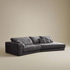 Budapest Lounger in charcoal grey ultra suede fabric featuring deep cushions and wide armrests on a warm beige studio background