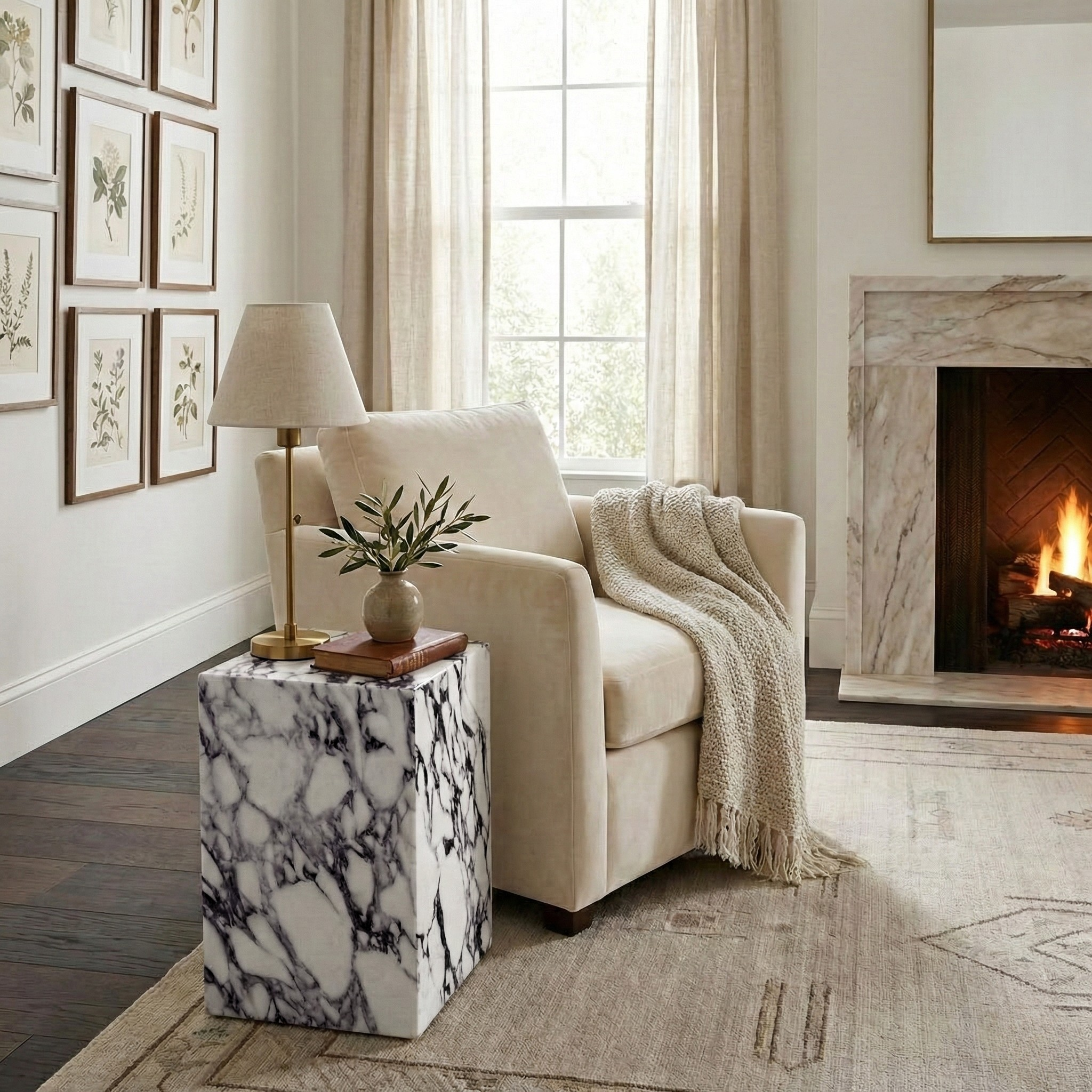 Bulgari Charm marble side table styled next to a cream armchair in a cozy living room with a fireplace.