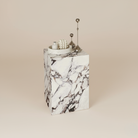 Bulgari Charm Tall Side Table with sculptural pedestal form and elegant veining, styled with decorative objects in studio setting