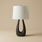 Table lamp with a dark wooden base and white lampshade on a beige background