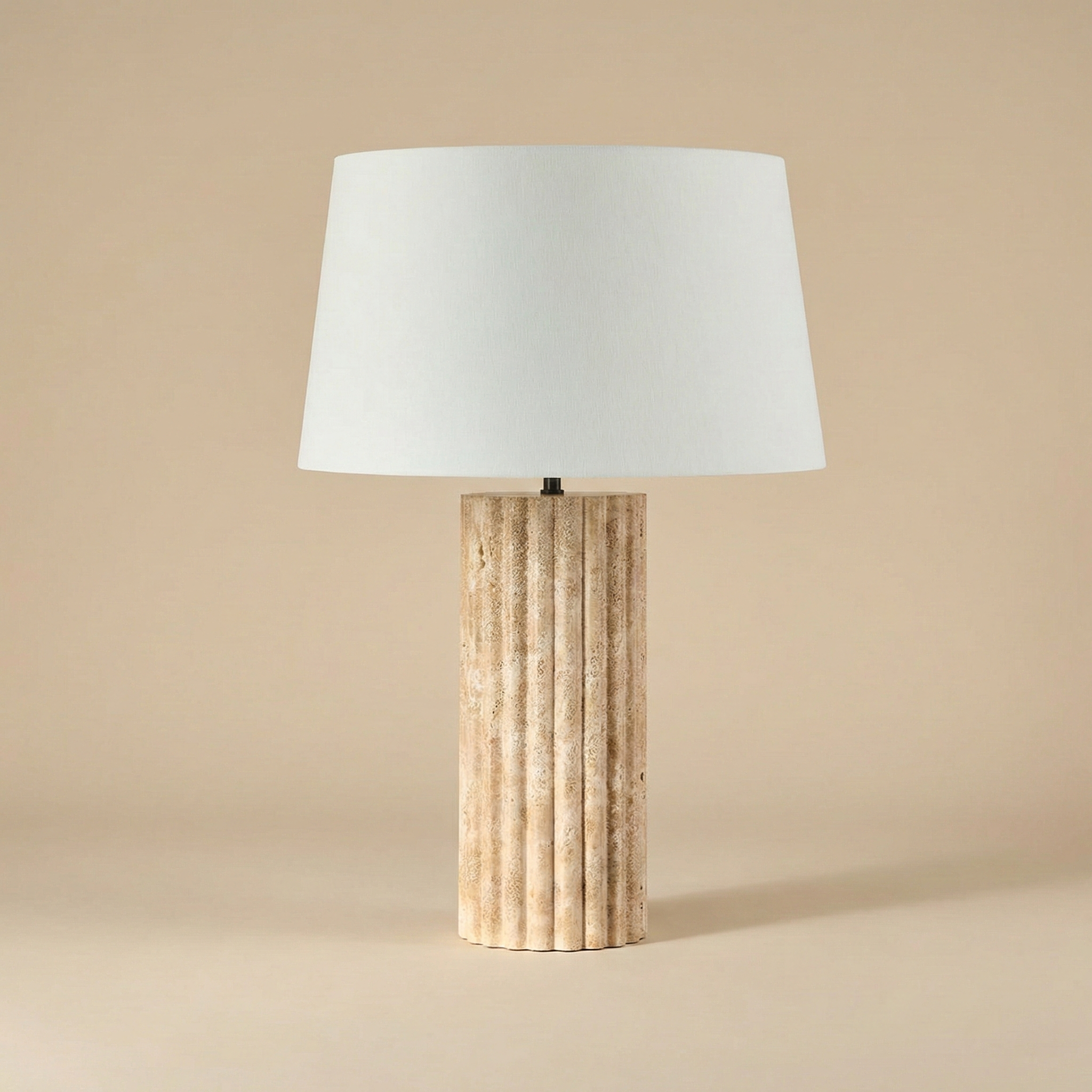 Table lamp with a textured wooden base and white shade on a beige background