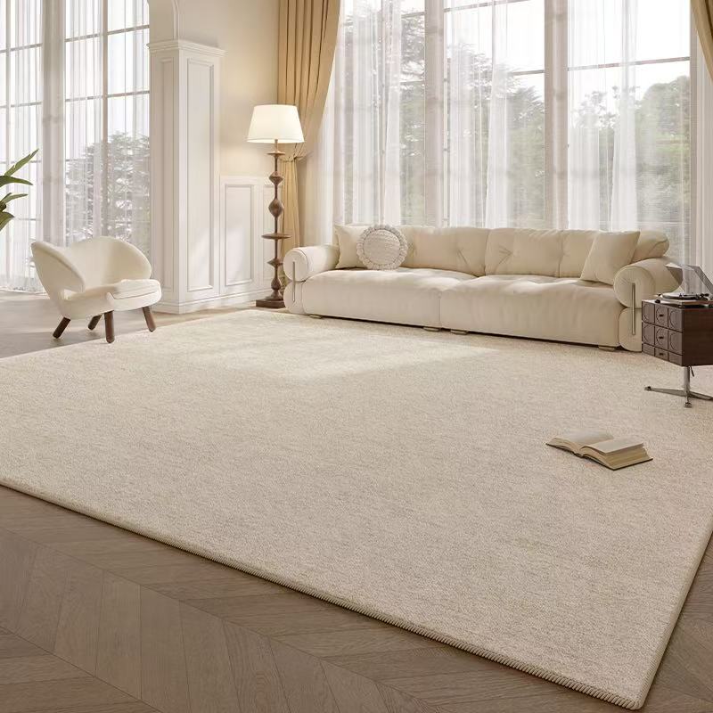 Caspian Rug styled in a bright living room with a cream sofa, armchair, and soft natural lighting from tall windows