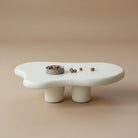 Cloud Shape Coffee Table with smooth sculptural design in matte white finish styled in a beige studio