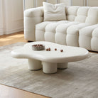 Cloud Shape Coffee Table with sculptural white base styled in cozy living room with cream boucle sofa and neutral rug