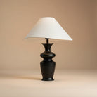 Contour Table Lamp with black sculpted base and asymmetrical white shade in a beige studio setting