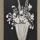Close-up of the Daphne wall art showing a painted white botanical floral arrangement against a solid black background.