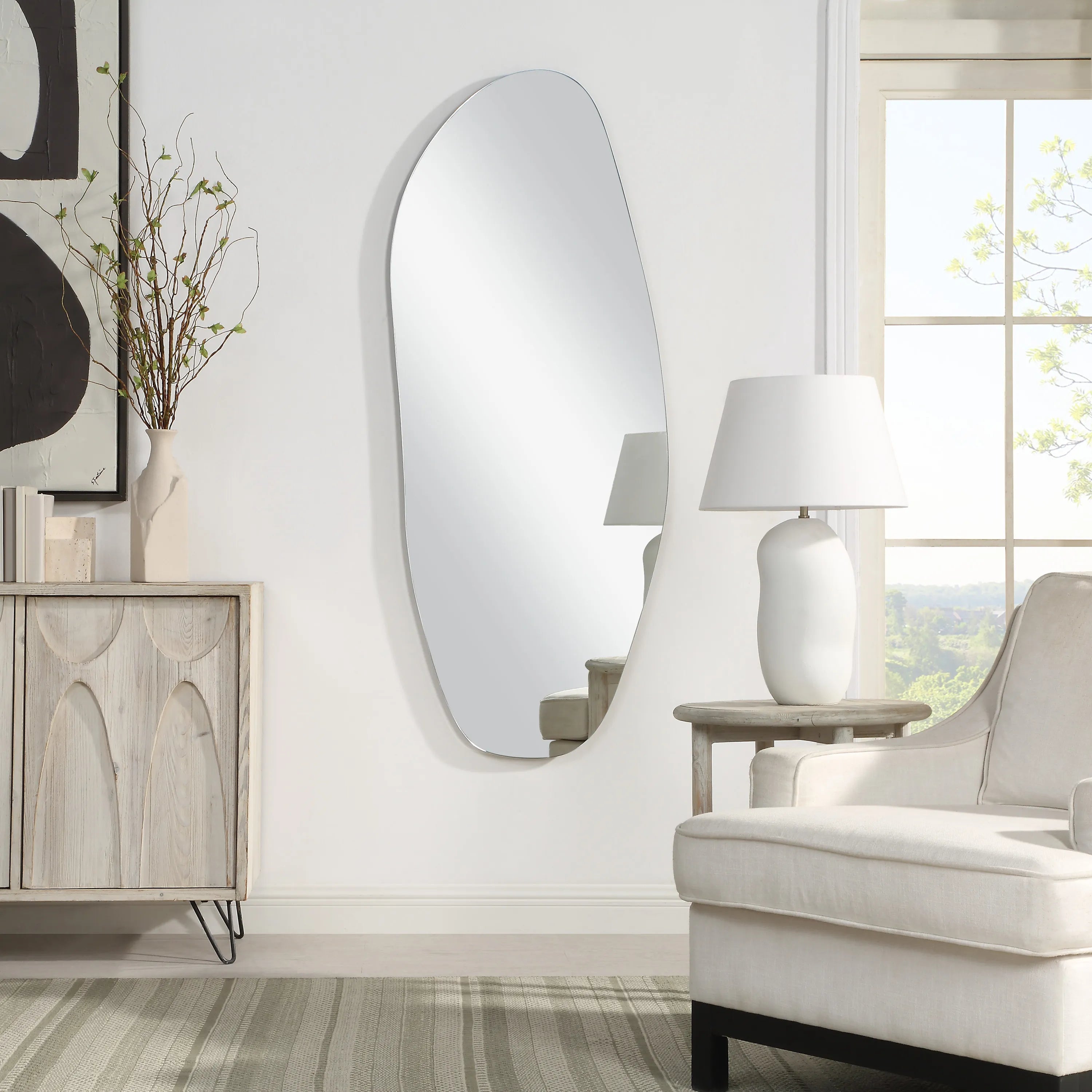 Drift Full Length Mirror mounted on a living room wall with an organic, irregular frameless shape.