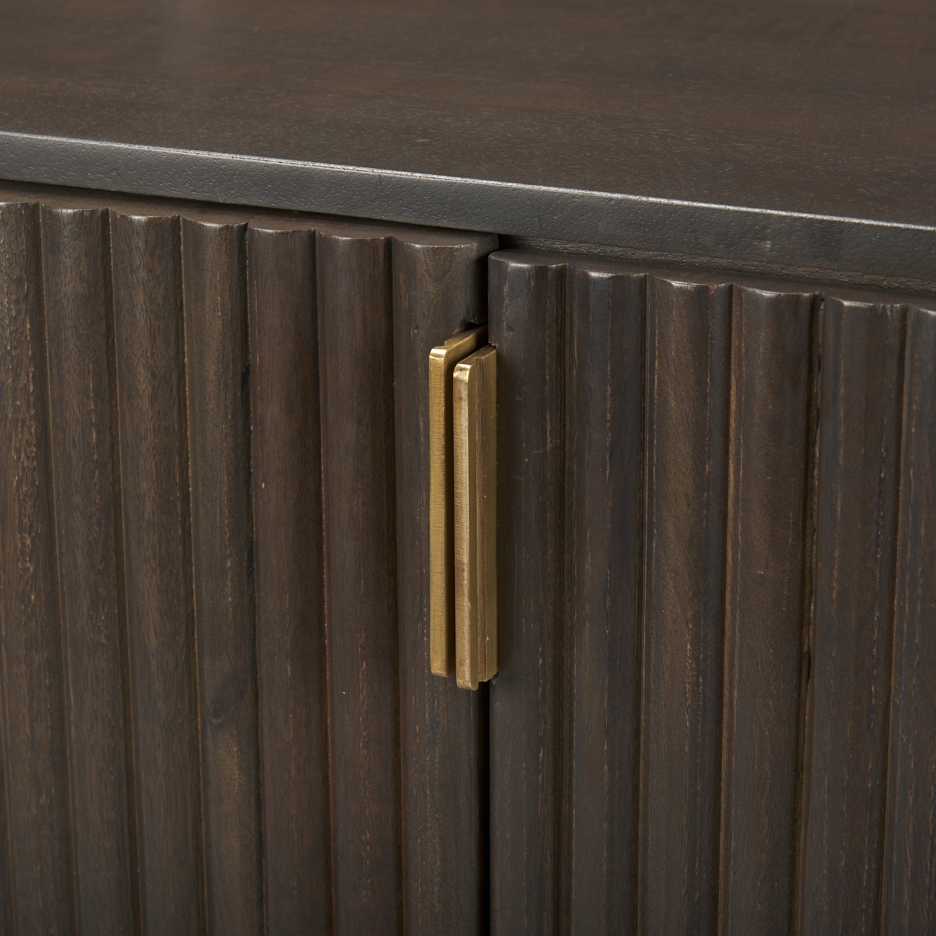 Macro detail of the textured fluted wood doors and vertical brass handles on the Eleanor sideboard.