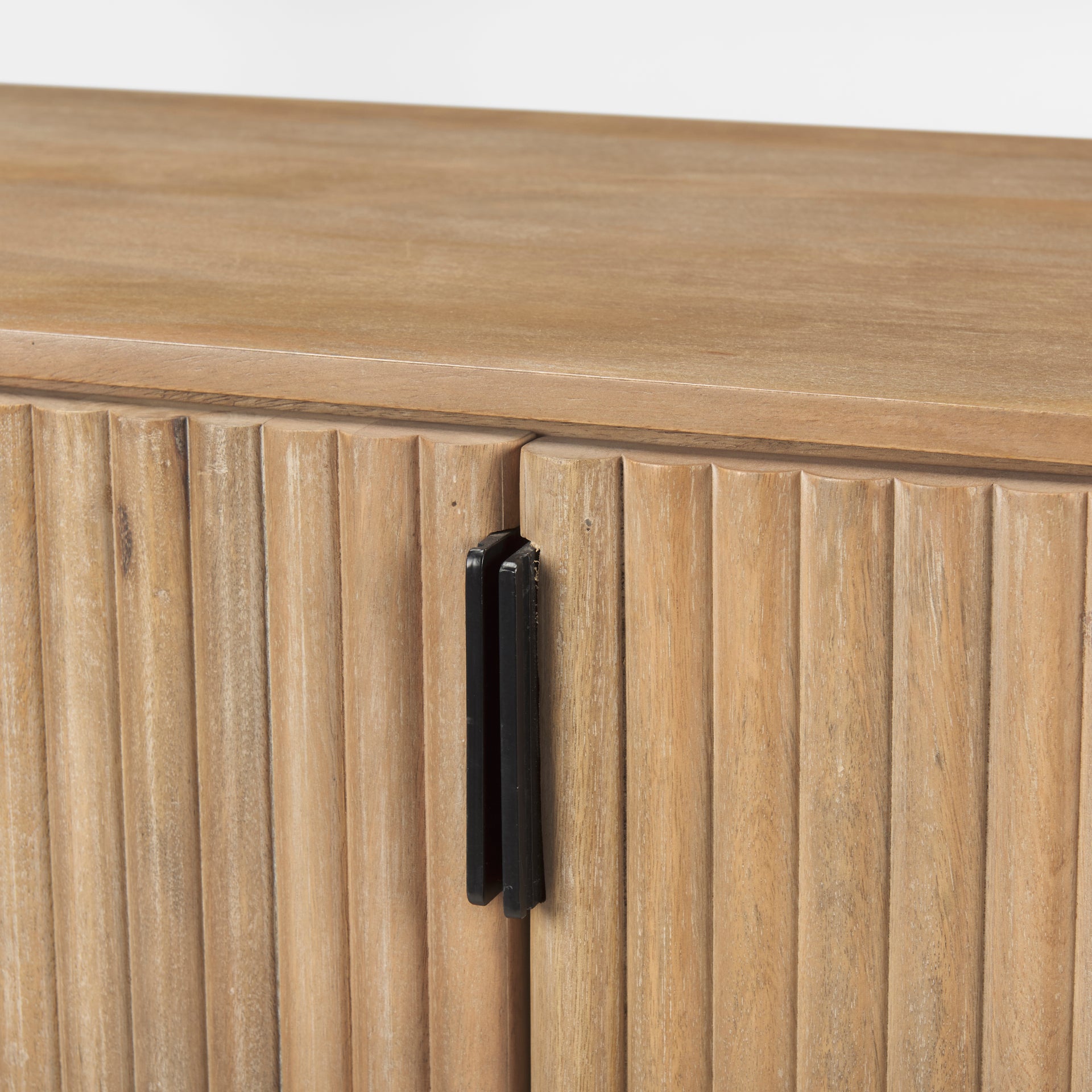 Macro detail of the textured fluted doors and matte black vertical hardware on the light wood Eleanor sideboard.