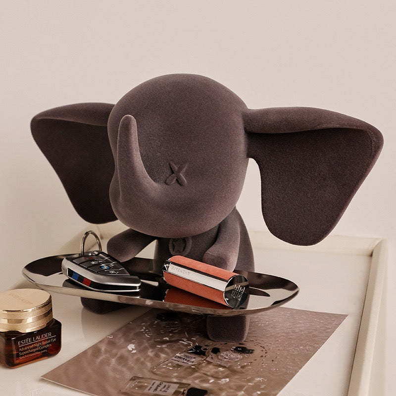 Elephant Sculpture Key Holder Tray in matte grey holding keys and lipstick on metal tray atop dresser