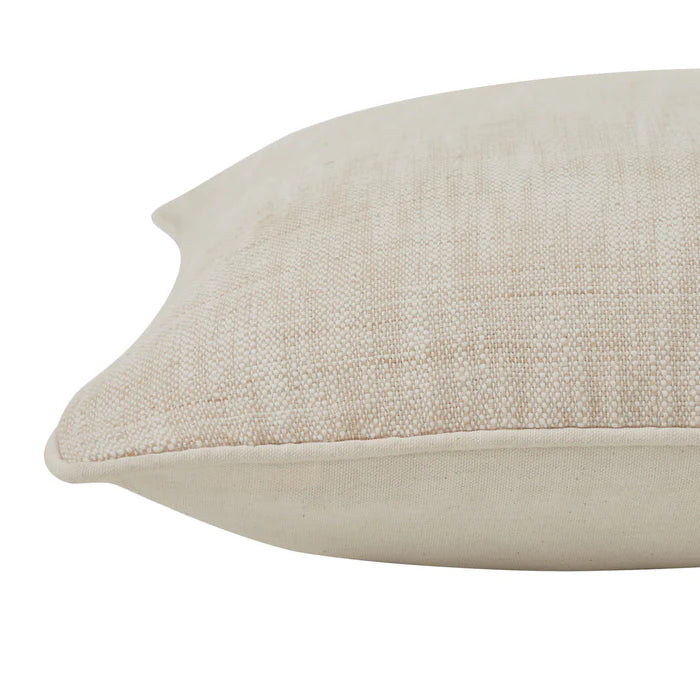 Close-up of the corner on the Eloise woven throw pillow highlighting the textured beige fabric and solid piped edge detail.