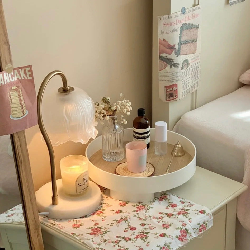 Glass Flower Candle Warmer Lamp on a cozy bedside table with lit candle and decorative accessories.