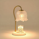Elegant Glass Flower Candle Warmer Lamp with frosted floral shade and brass curved stand warming a lit candle.