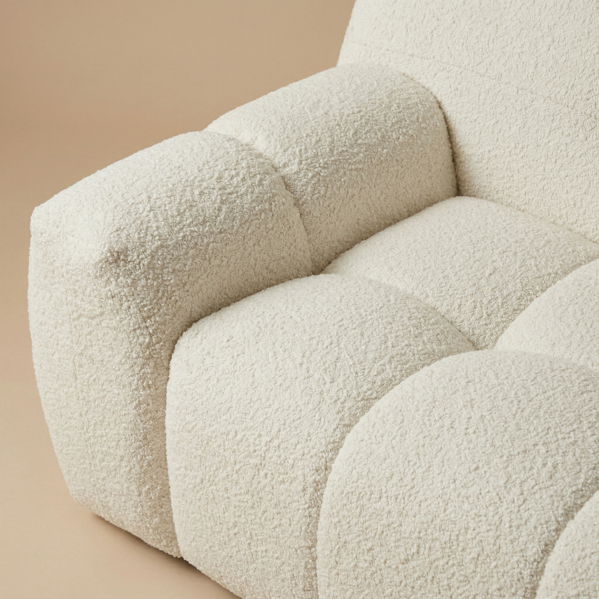 Macro close-up of the Gummy sofa highlighting the deep vertical channeling and the rich, nubby texture of the cream bouclé.