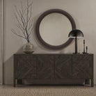 Harrison bronze table lamp styled on a dark wood sideboard in a modern entryway with a round mirror and ceramic decor.