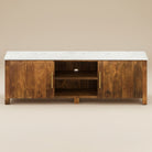 Harrison Marble TV Stand with white marble top and natural wood base featuring cabinets and open shelves.