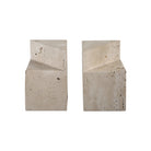 Front profile view of the heavy stone bookends, highlighting the raw, organic pitting and warm beige tones of the natural travertine.