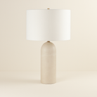 Iris Onyx Table Lamp with smooth cylindrical beige onyx base and white drum shade on neutral studio background"