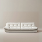 Italian-style Cloud Sofa in cream upholstery with deep tufted cushions and low modern silhouette on a beige studio background