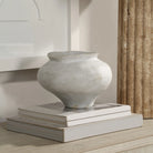 Leros Vase styled on stacked neutral books beside textured column and framed wall art
