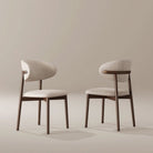 Two Linen Ash Wood Dining Side Chairs with curved upholstered backs and ash wood frames, shown in a neutral studio setting