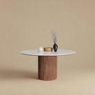 Lucia Dining Table with round sintered stone top and fluted cylindrical wood base styled in a neutral studio setting